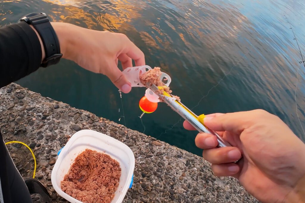 ぶっこみサビキのカゴに撒き餌を詰め込んでいる